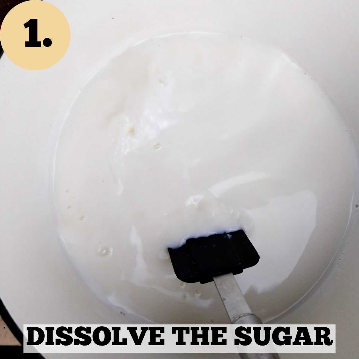 White milk in a white Dutch oven with a black silicone spatula stirring the milk.