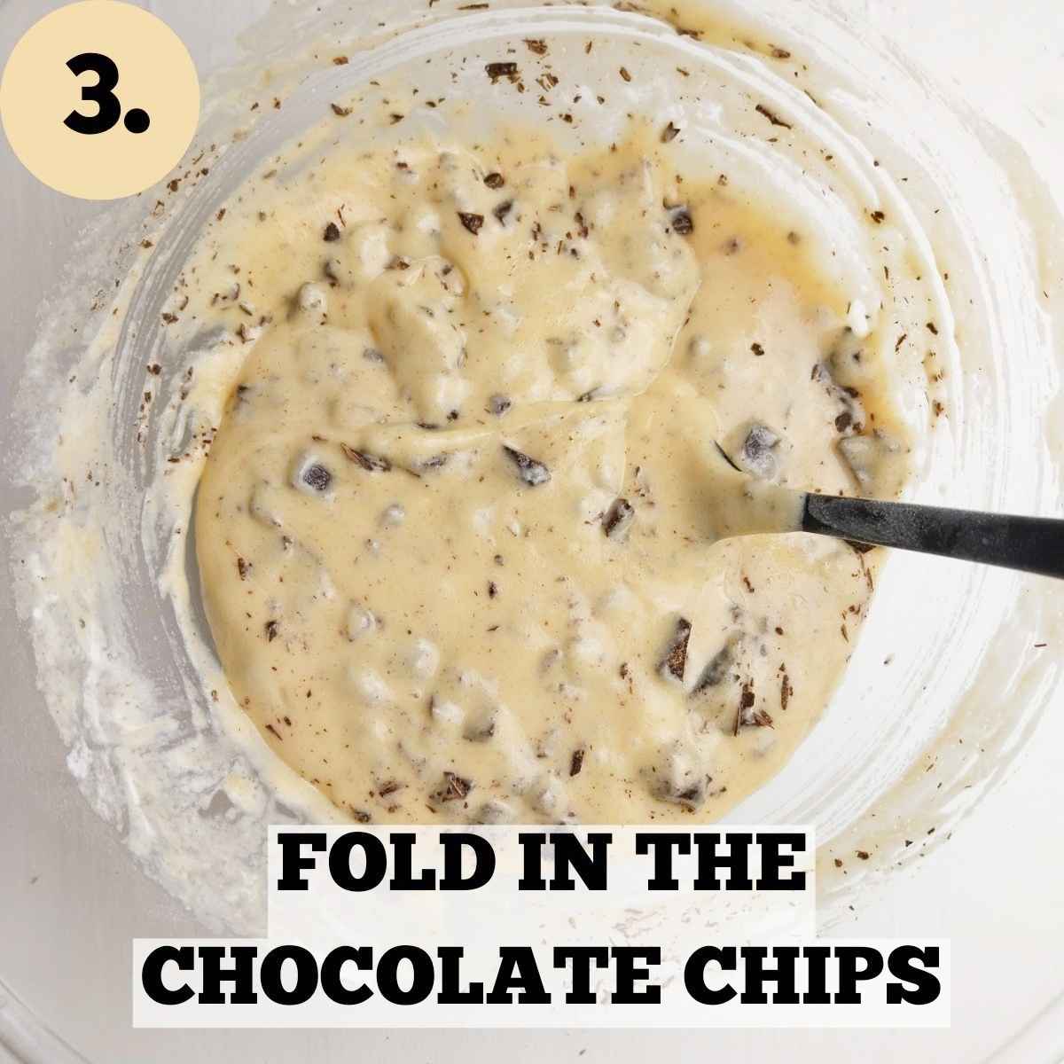 The rice muffin batter with chocolate chips folded in and a black spatula inside the mixing bowl.