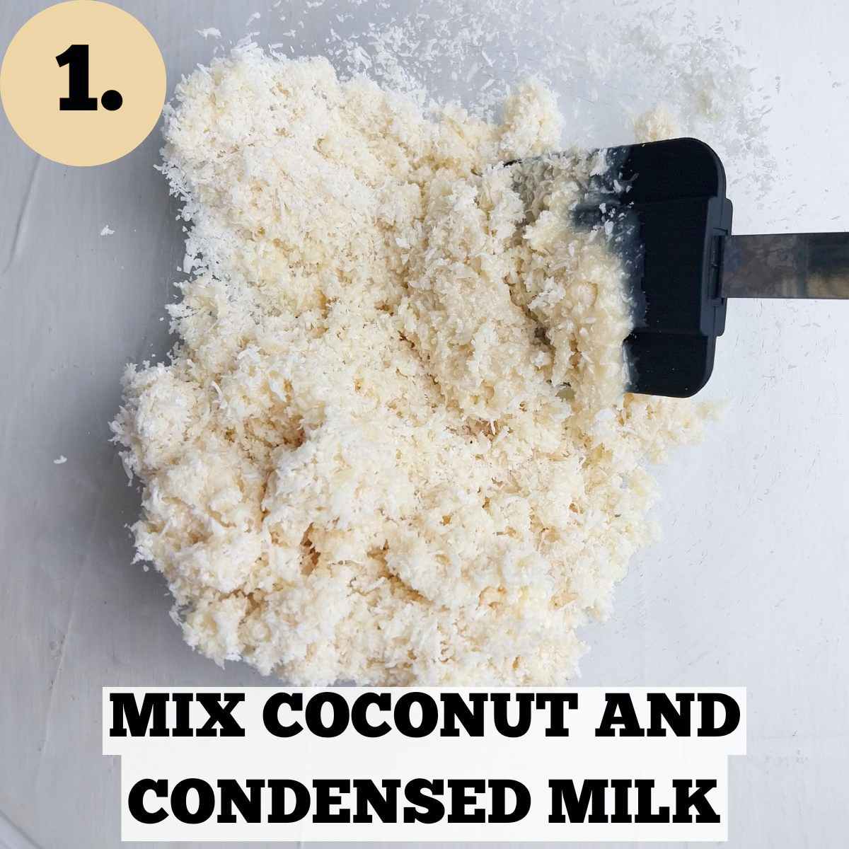 Mixed desiccated coconut with condensed milk in a glass bowl with a black silicone spatula.