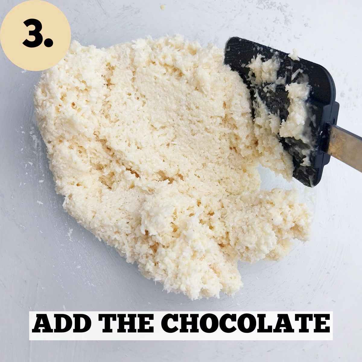Raffaello dough mixed in a mixing bowl with a black metal spatula in it.