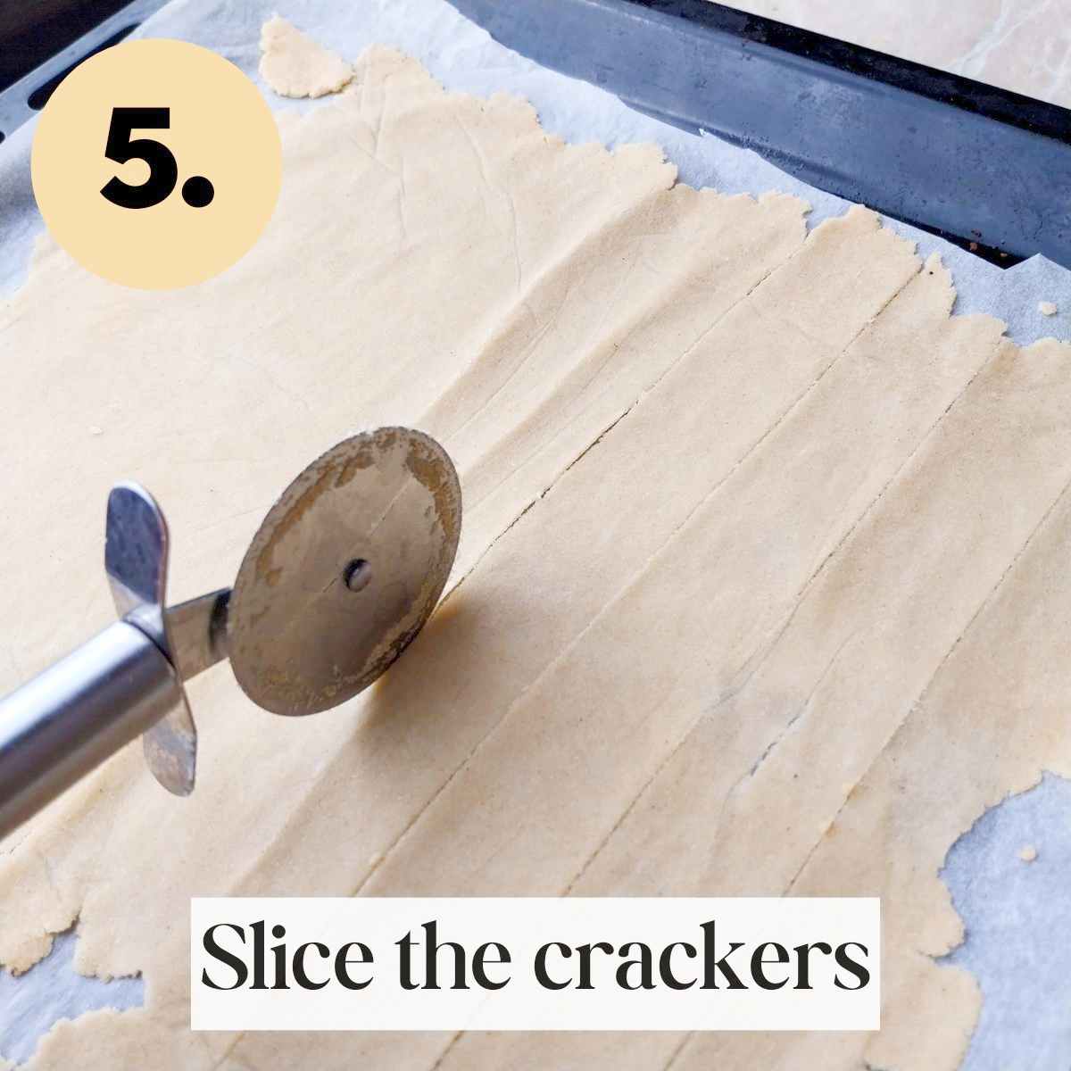 Thin rolled out cassava dough with a pizza cutter slicing it in stripes.