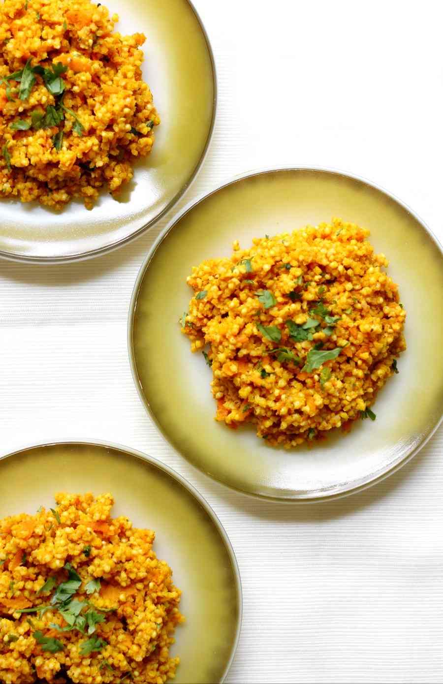 African millet meal in three greet plates on a white kitchen surface.