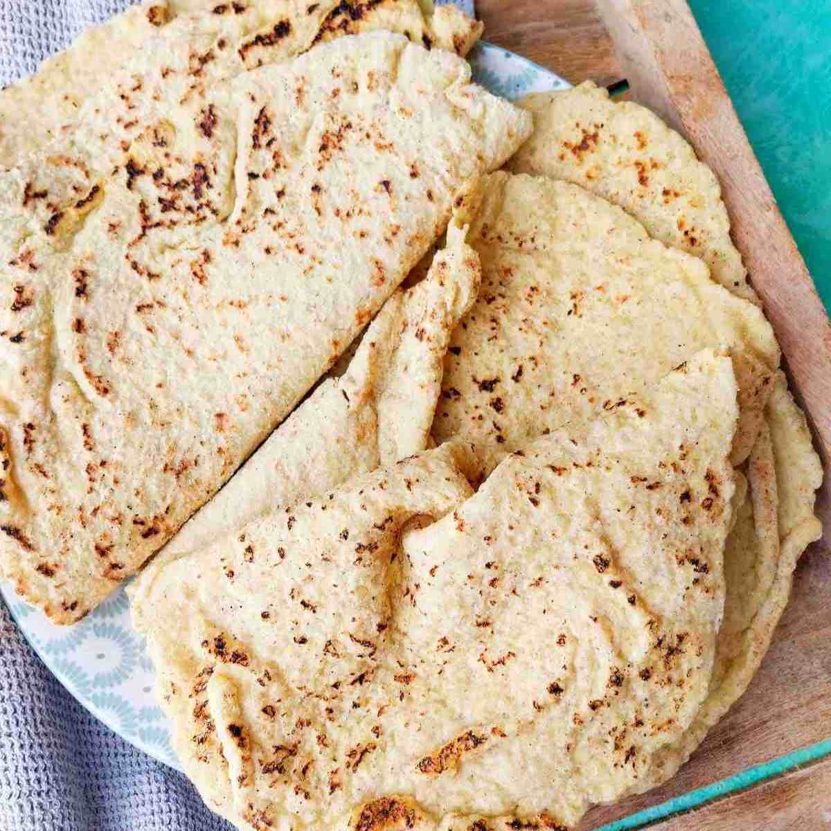 Bajra roti (millet flatbread) on a wooden surface with a kitchen towel in the background.