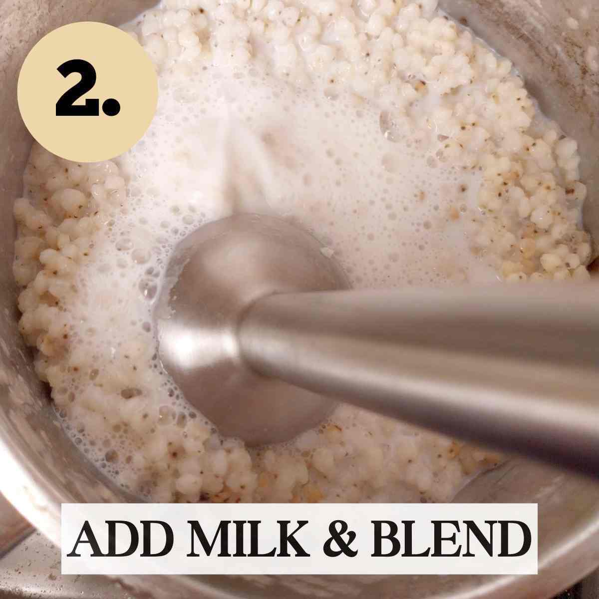 Blending sorghum grain in milk with a stick blender in a metal saucepan.